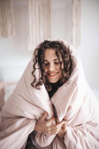 A woman seeking anxiety treatment wrapped up in a pink blanket.